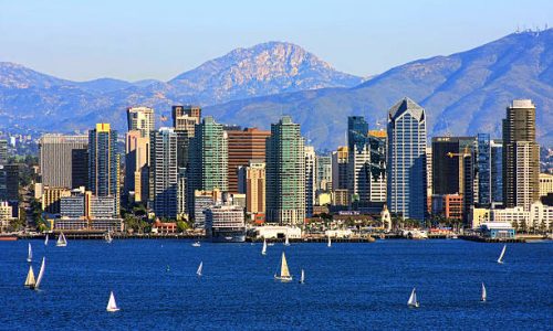 San Diego skyline from bay with mountains in background.